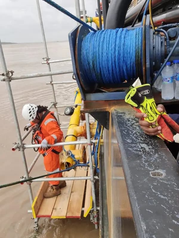 Technician working from a suspended platform over water